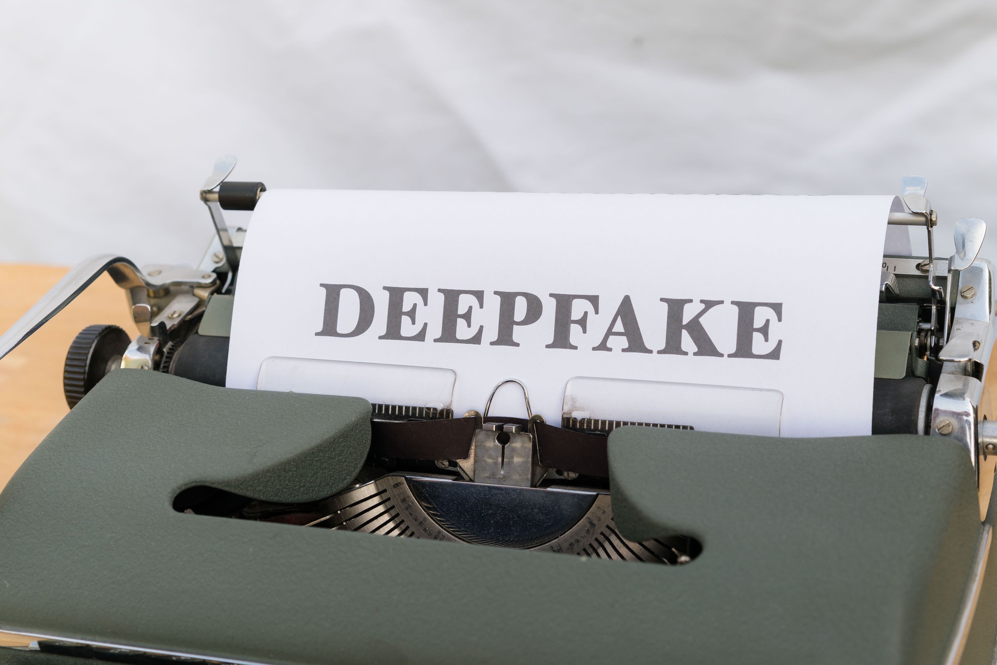 Vintage typewriter with a paper labeled 'DEEPFAKE', symbolizing AI-generated online content