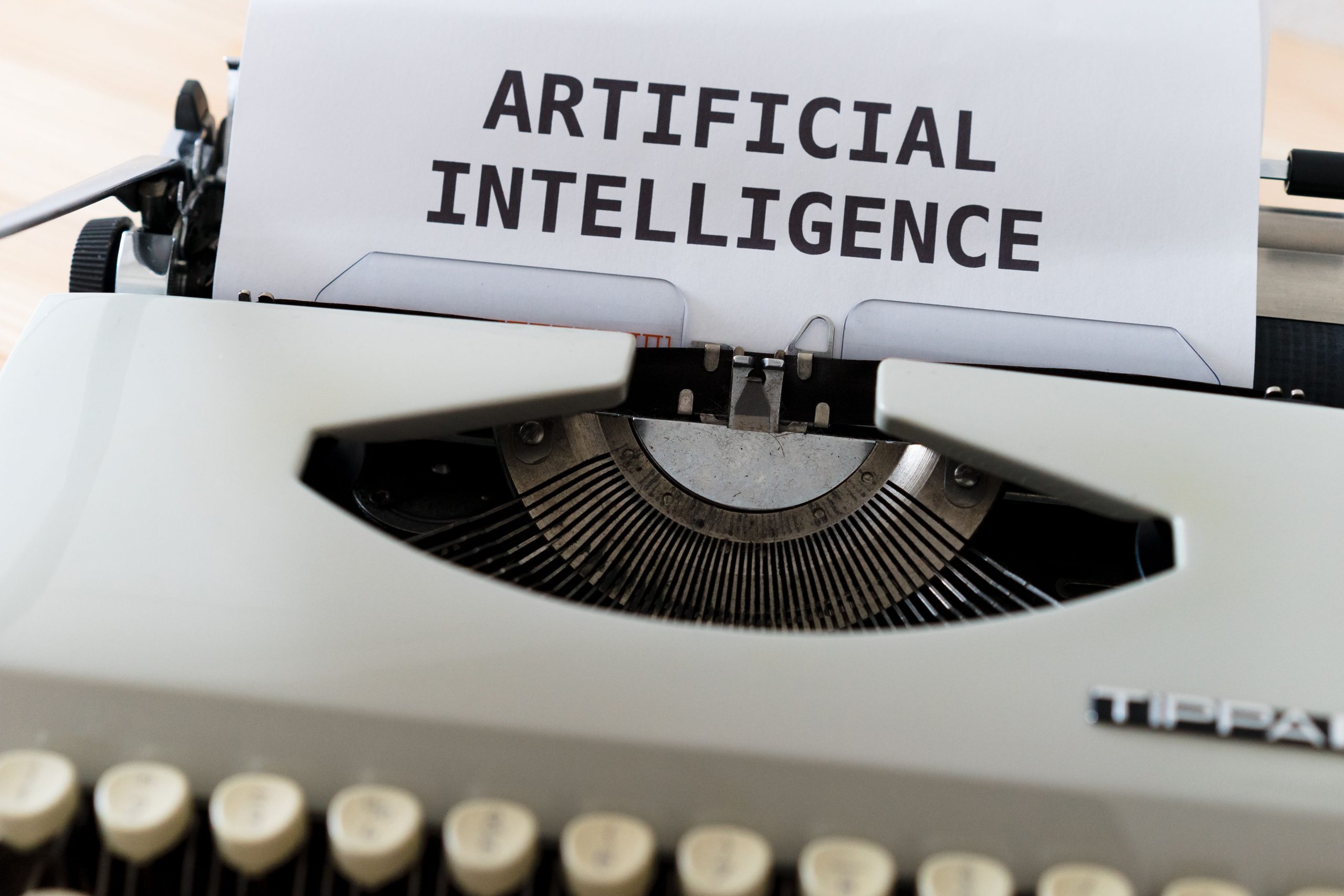 Close-up of a typewriter printing the words 'ARTIFICIAL INTELLIGENCE' on paper, symbolizing AI-generated writing