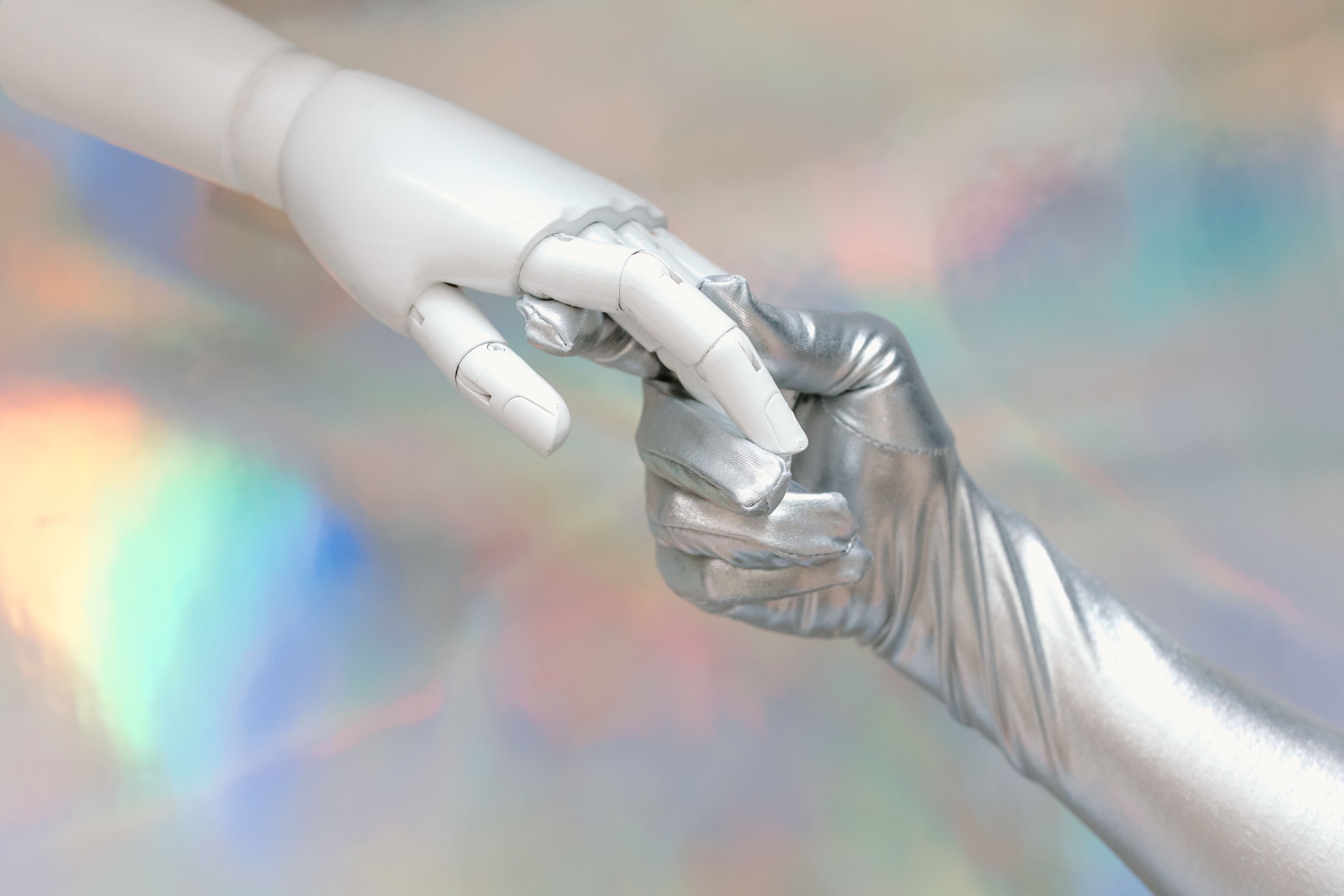 A robot hand and a silver-gloved human hand touching, symbolizing the blurring line between AI and human writing